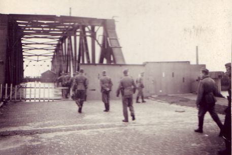 Duitse militairen bij de Keizersveerse Brug. Gepantserde schuifdeuren aan de zuidelijke toegang van de brug, schietsleuven en een kleine toegangsdeur zijn duidelijk waarneembaar.